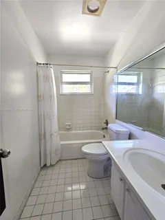 a bathroom with a sink a toilet a mirror a bathtub and shower