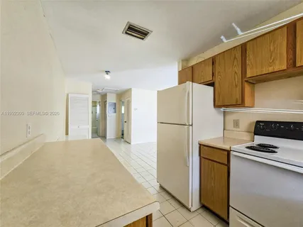 a kitchen with a refrigerator and a stove top oven