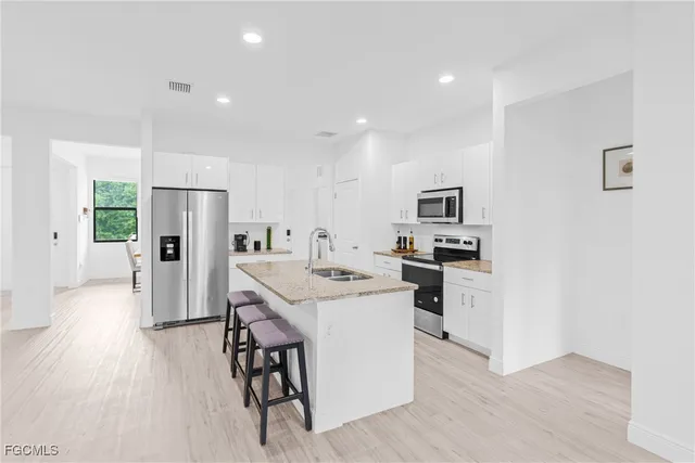 a kitchen with stainless steel appliances kitchen island a refrigerator and a stove top oven