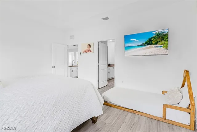 a spacious bedroom with a bed and a flat screen tv