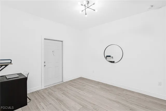 a view of a room with wooden floor and a ceiling fan