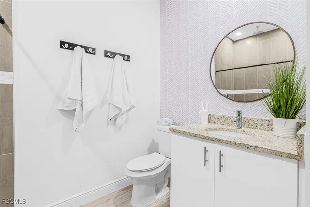 a bathroom with a granite countertop sink toilet and shower