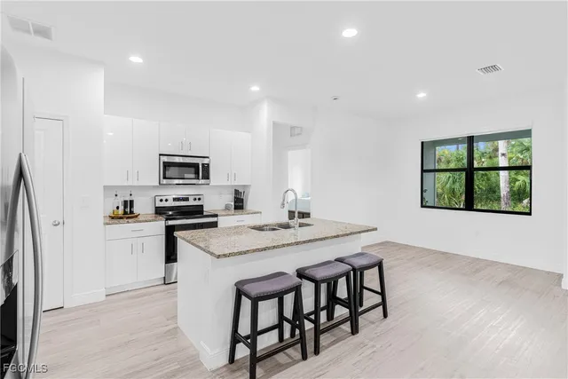 a kitchen with stainless steel appliances granite countertop a stove a sink and a refrigerator