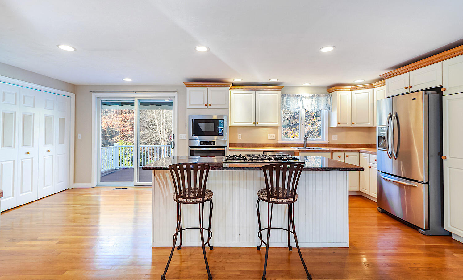 22 Weather Crescent Circle Mashpee, MA 02649 - Photo 8 of 29 a kitchen with granite countertop a refrigerator a sink dishwasher a dining table and chairs with wooden floor