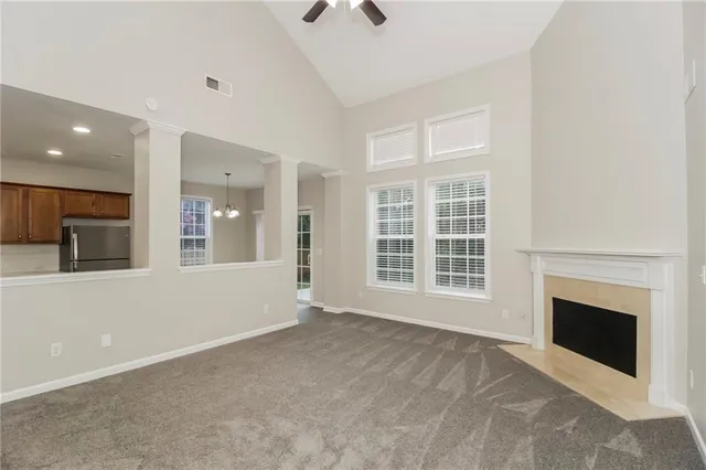 a view of an empty room with a fireplace and a window