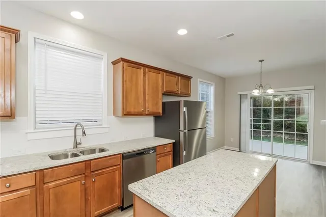 a kitchen with stainless steel appliances granite countertop a sink refrigerator and cabinets