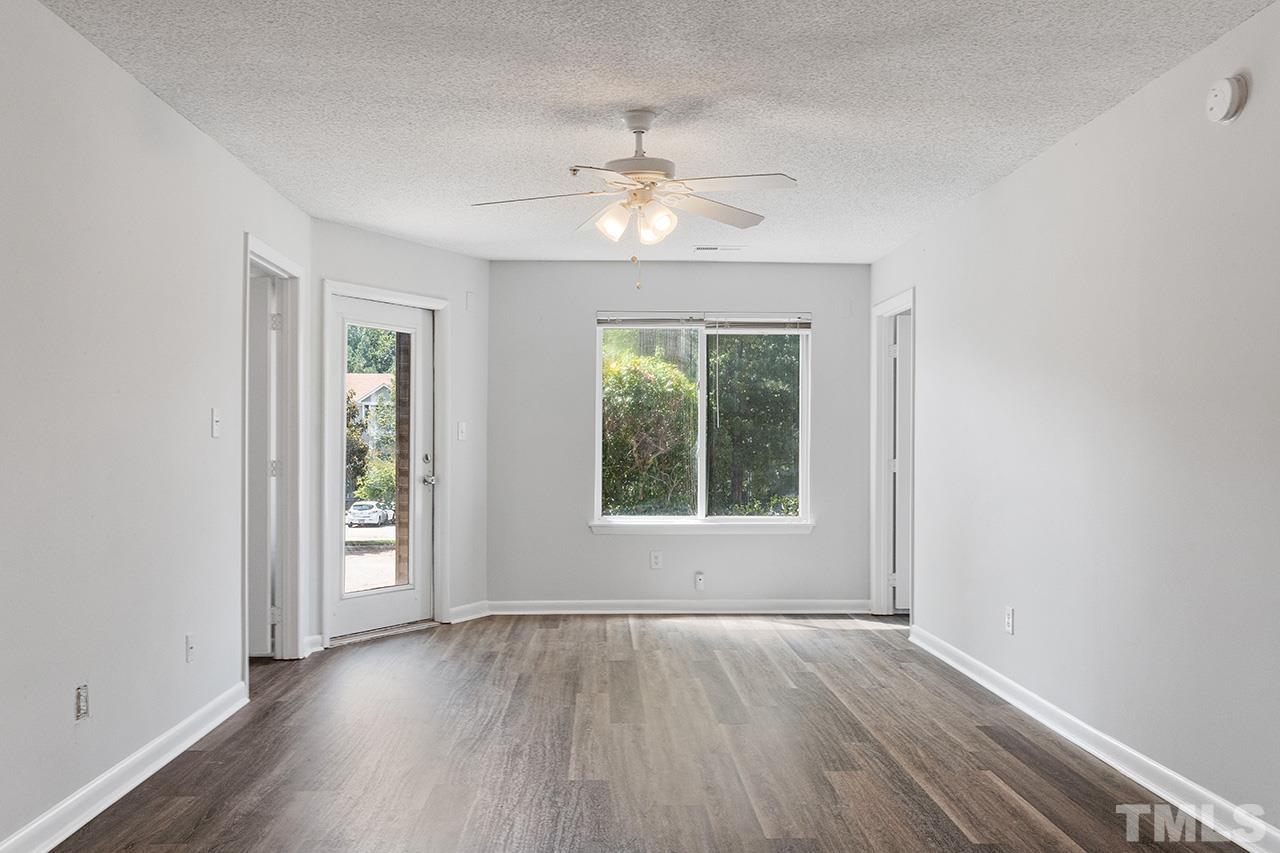 1241 University Court, Unit 2 Raleigh, NC 27606 - Photo 20 of 34 an empty room with wooden floor chandelier fan and windows