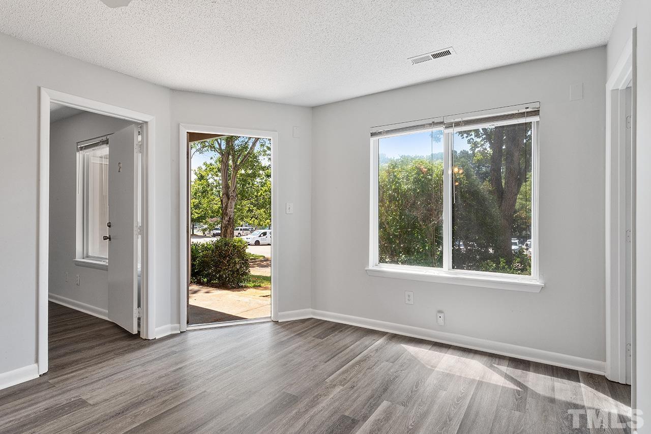 1241 University Court, Unit 2 Raleigh, NC 27606 - Photo 23 of 34 a view of an empty room with wooden floor and a window