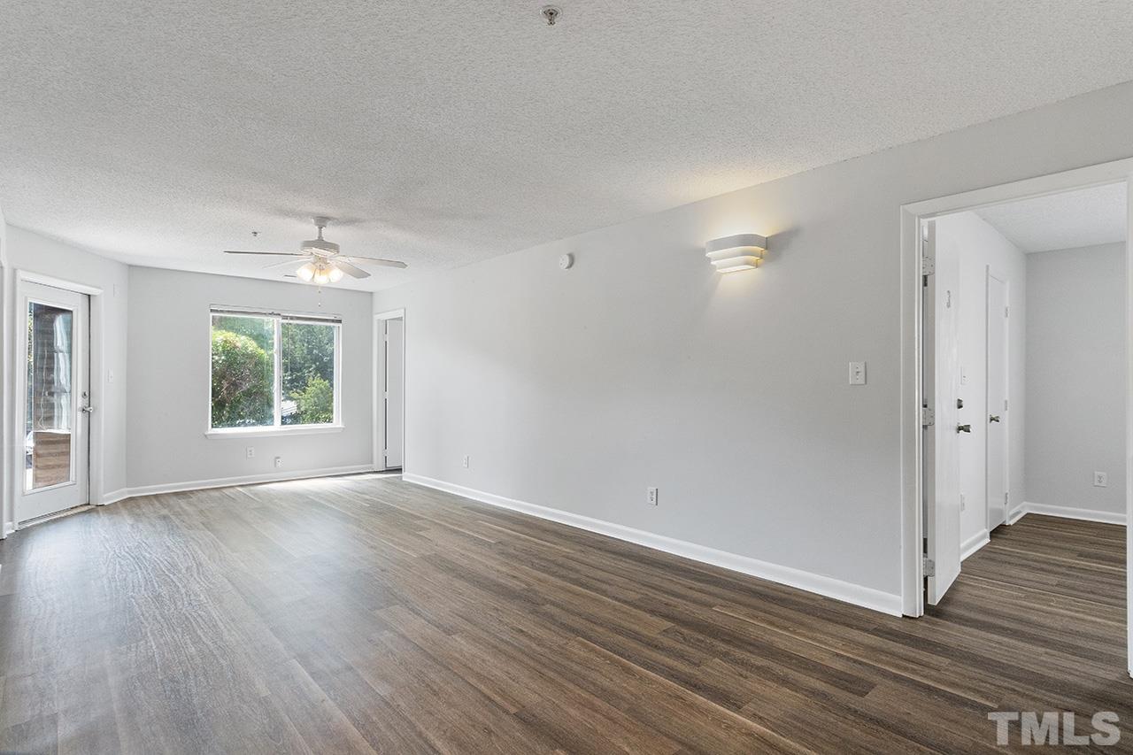 1241 University Court, Unit 2 Raleigh, NC 27606 - Photo 3 of 34 a view of an empty room with wooden floor and a window