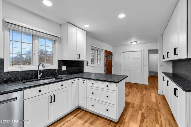 a kitchen with granite countertop a sink and cabinets