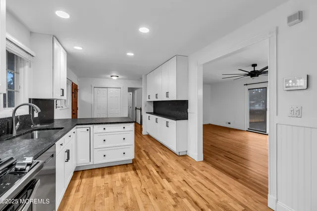 a large kitchen with stainless steel appliances granite countertop a stove and a sink