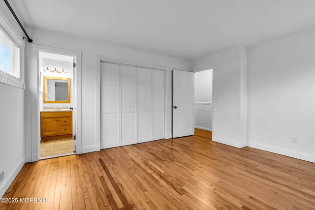 a view of empty room with wooden floor and cabinet