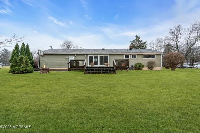 a view of a house with a big yard and large trees