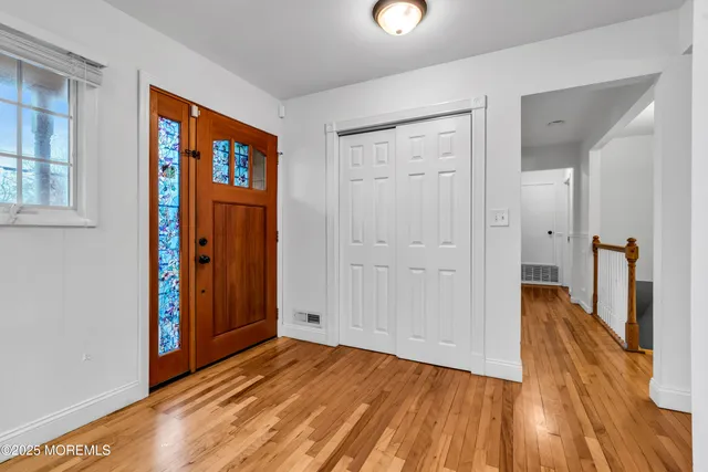 a view of a hallway with wooden floor and closet area