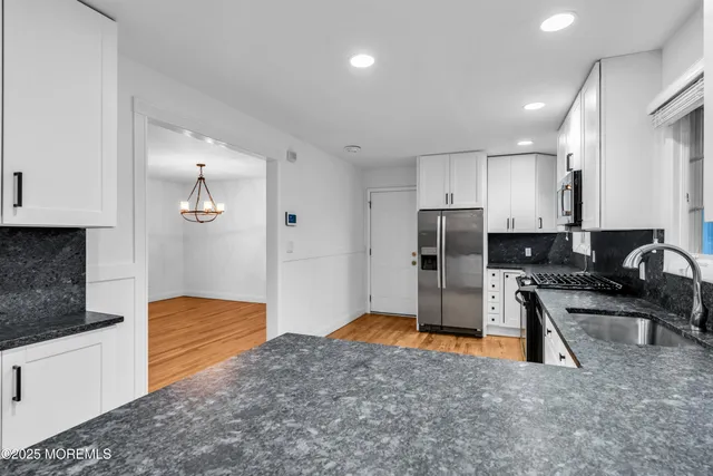 a kitchen with stainless steel appliances granite countertop a stove a sink and a refrigerator