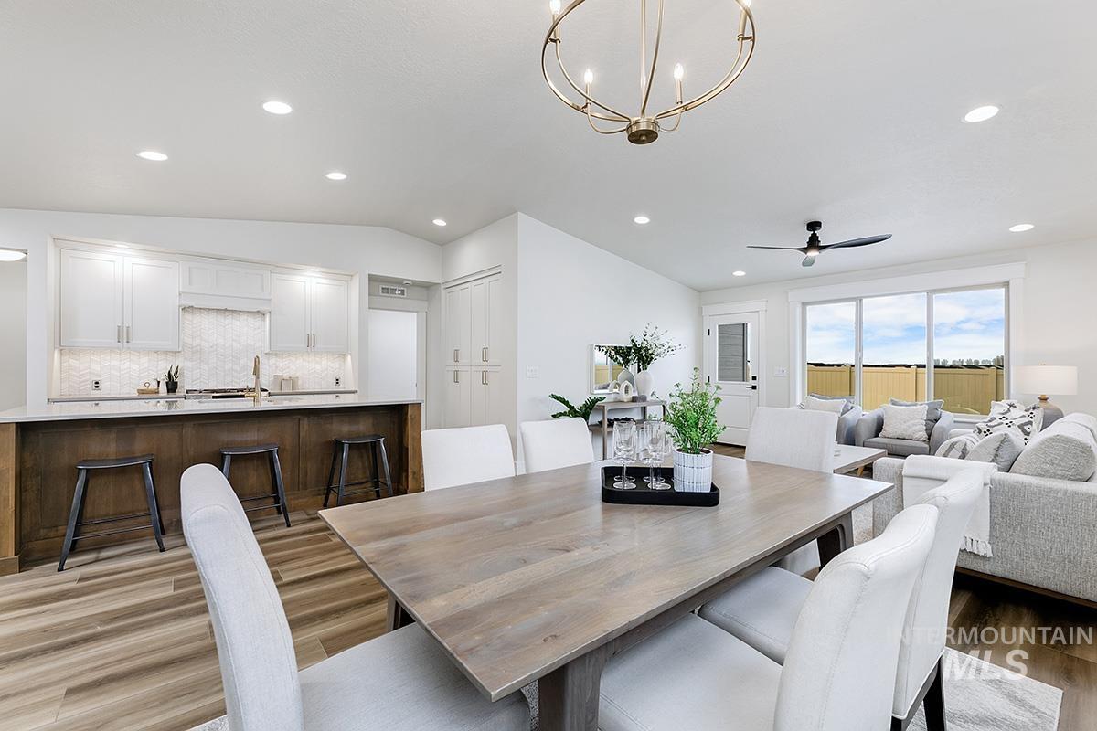 6975 South Skybreak Lane Meridian, ID 83642 - Photo 6 of 29 Dining space with light wood-style flooring, vaulted ceiling, suspended lighting, and ceiling fan