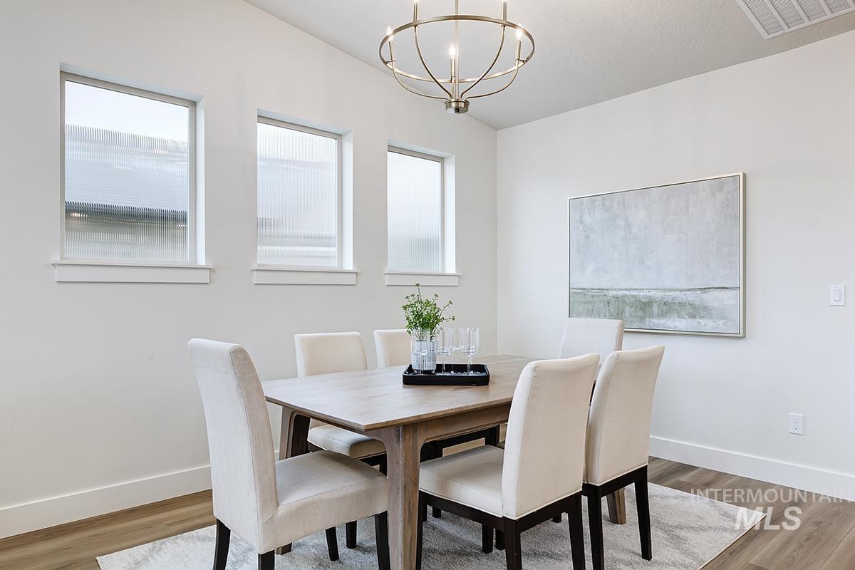 6975 South Skybreak Lane Meridian, ID 83642 - Photo 7 of 29 Dining room featuring healthy amount of natural light, light wood-style floors, and suspended lighting