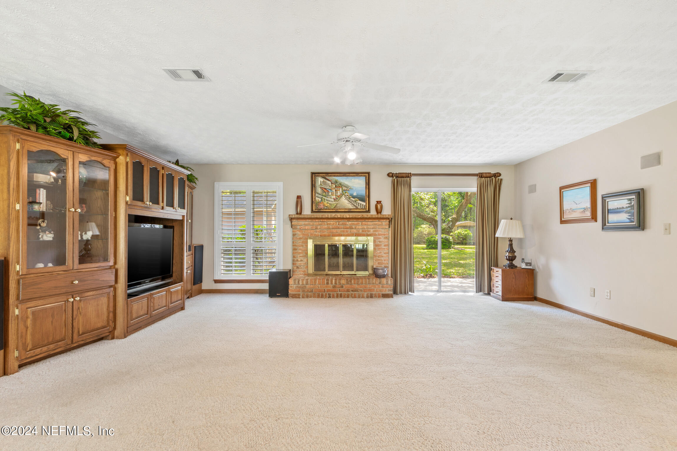 3153 Tiger Hole Road Jacksonville, FL 32216 - Photo 12 of 68 a view of an empty room with a fireplace and a window