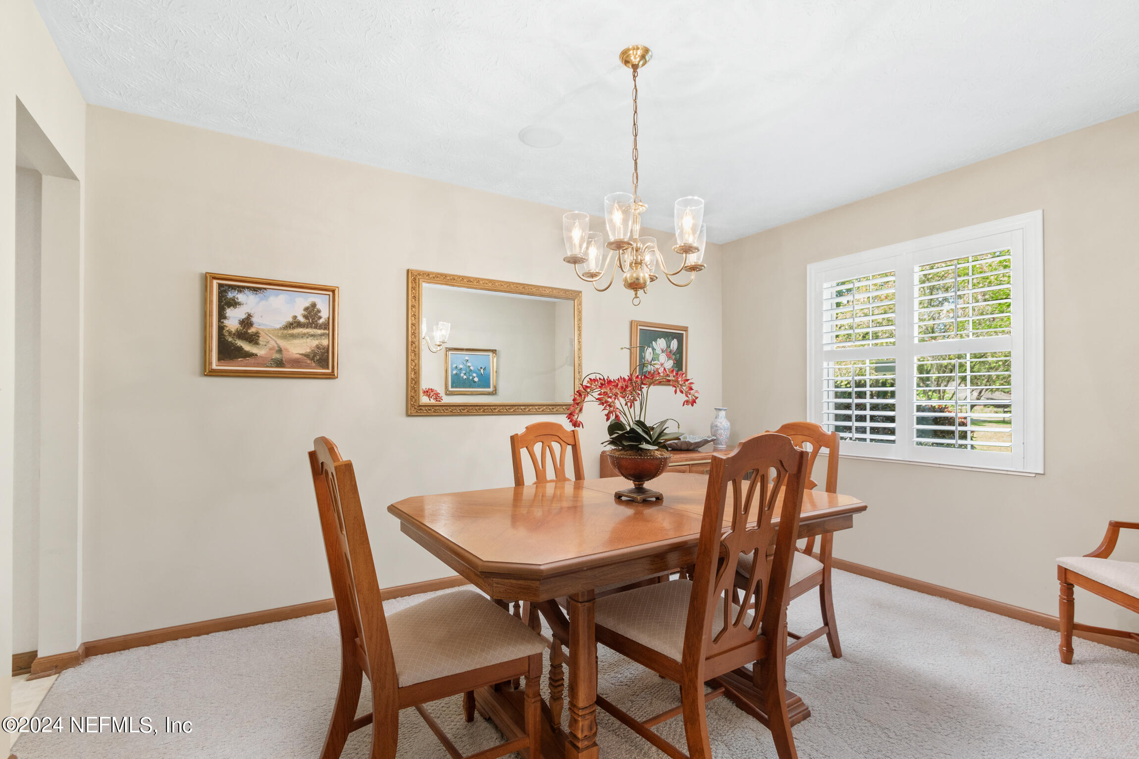 3153 Tiger Hole Road Jacksonville, FL 32216 - Photo 17 of 68 a view of a dining room with furniture and chandelier