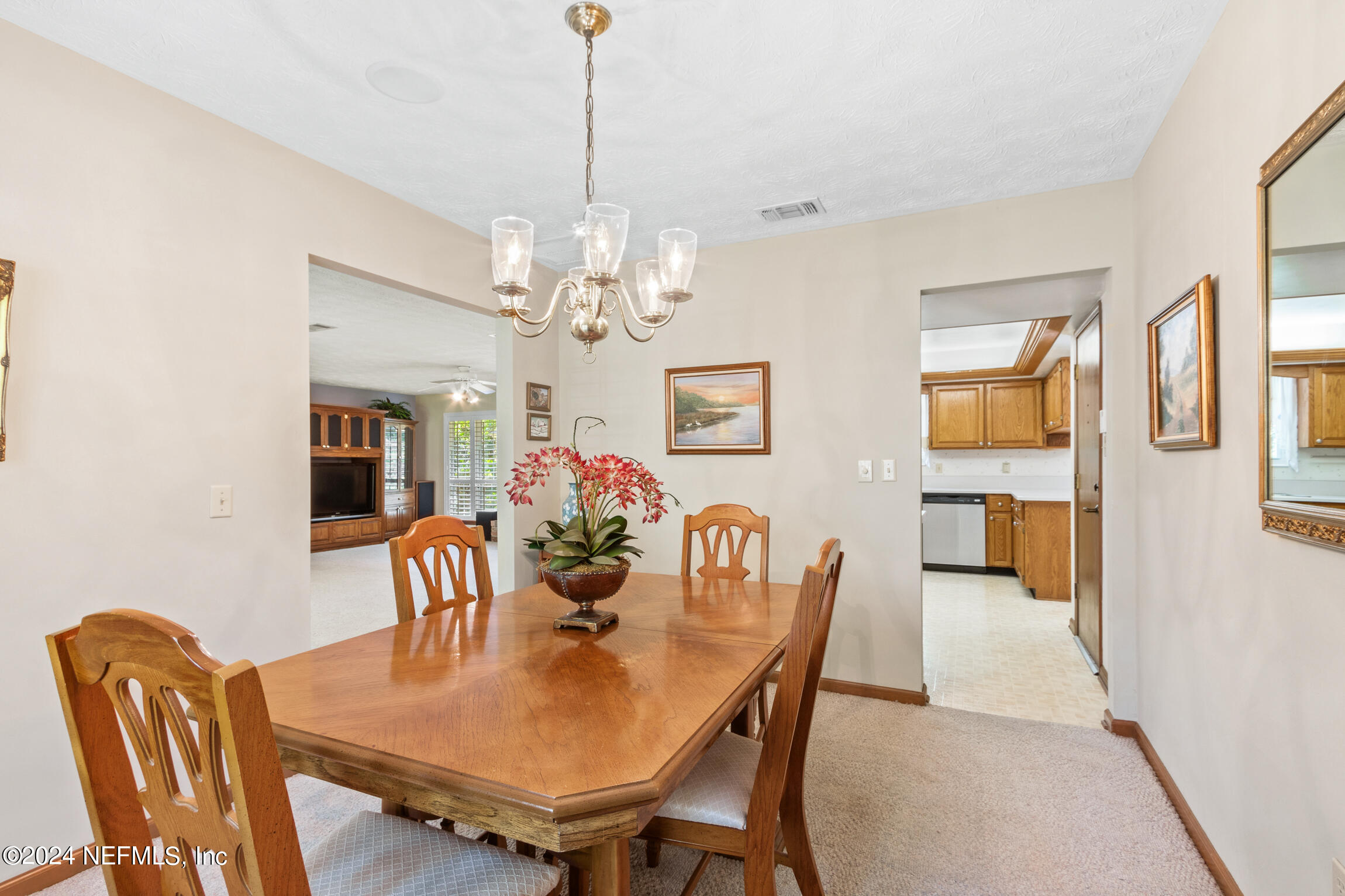 3153 Tiger Hole Road Jacksonville, FL 32216 - Photo 18 of 68 a view of a dining room with furniture and chandelier