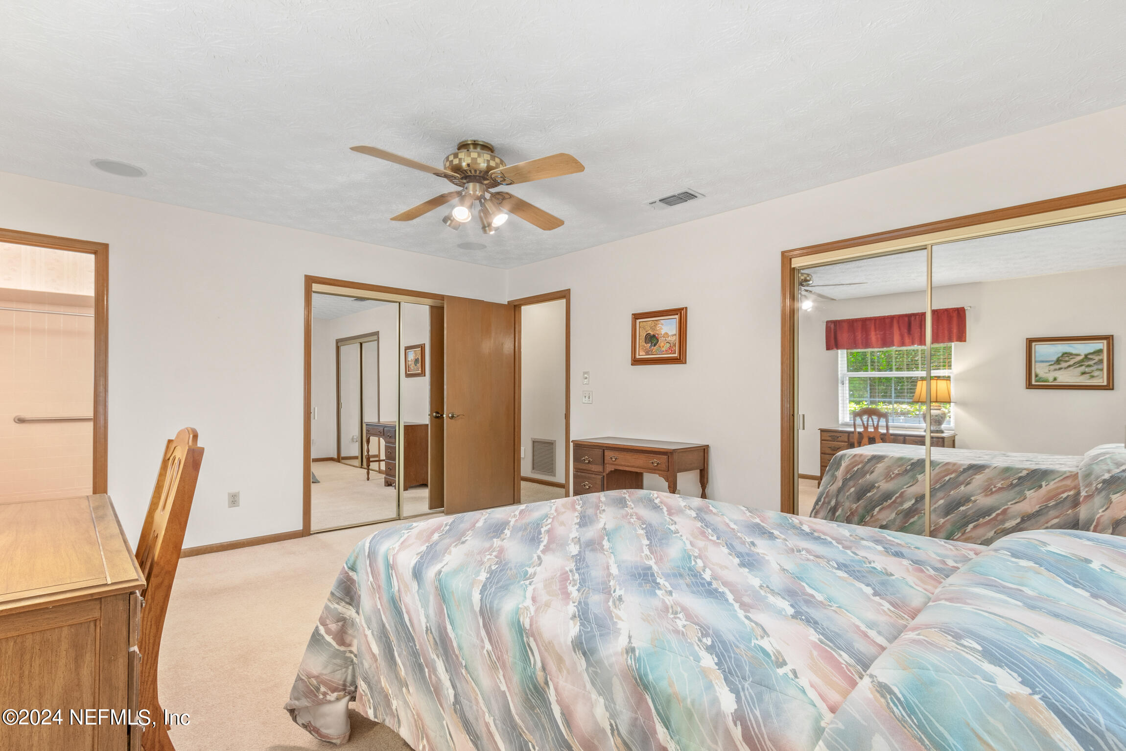 3153 Tiger Hole Road Jacksonville, FL 32216 - Photo 30 of 68 a bedroom with a large bed and a chandelier