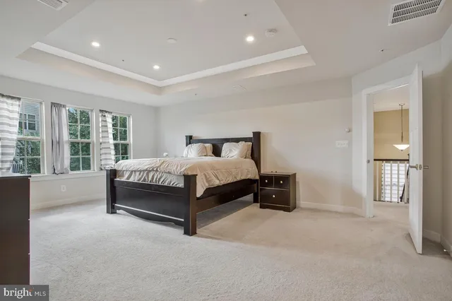 a spacious bedroom with a bed and wooden floor