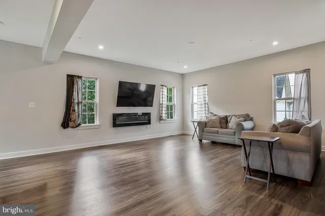 a living room with furniture flat screen tv and wooden floor