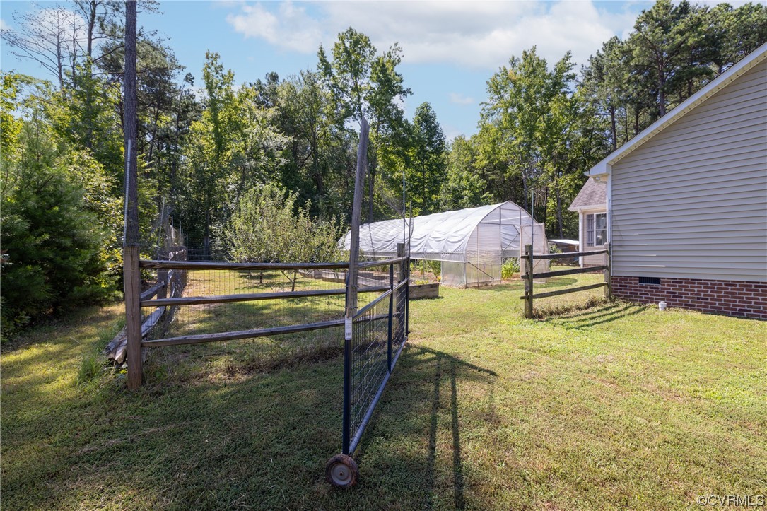 2624 Academy Road Powhatan, VA 23139 - Photo 28 of 46 View of fenced in back yard with fruit trees, raised beds and high tunnel