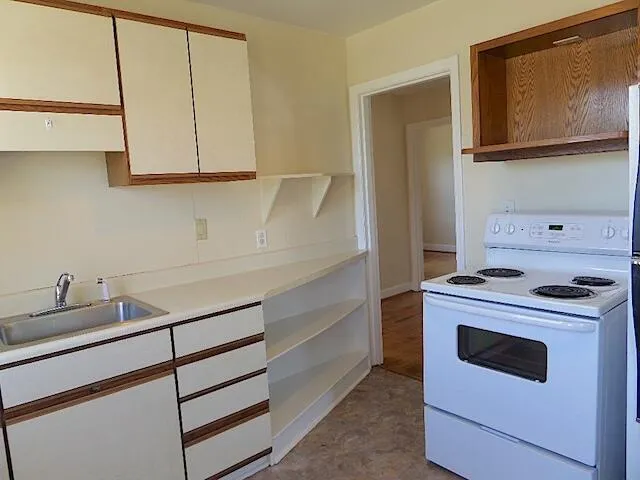 a kitchen with white cabinets and white appliances