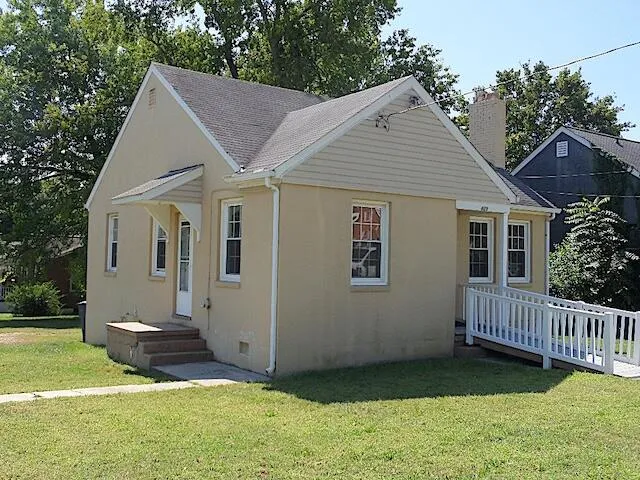 a view of a house with a yard and deck