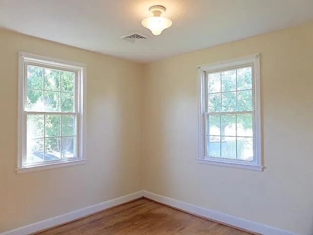 a view of a room with wooden floor and windows