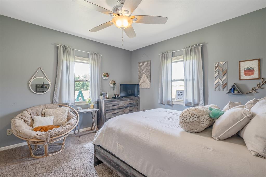 13043 County Road 4182 Henderson, TX 75654 - Photo 20 of 40 a bedroom with a bed and a chandelier