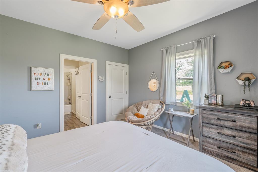 13043 County Road 4182 Henderson, TX 75654 - Photo 21 of 40 a bedroom with a bed and a chandelier