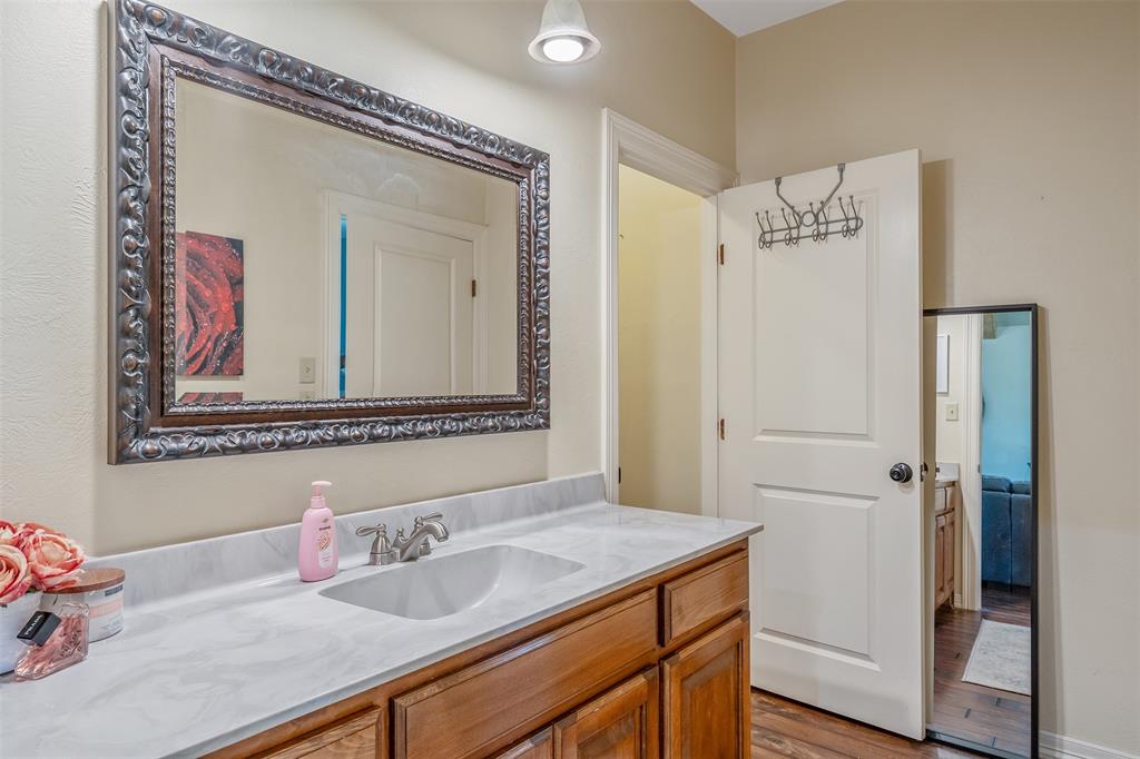 13043 County Road 4182 Henderson, TX 75654 - Photo 22 of 40 a bathroom with a granite countertop sink and a mirror