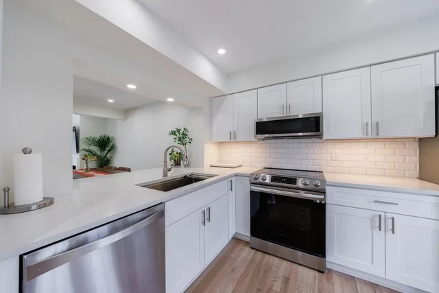 a kitchen with a sink a stove and cabinets