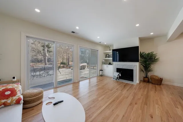 a living room with furniture a fireplace and a floor to ceiling window