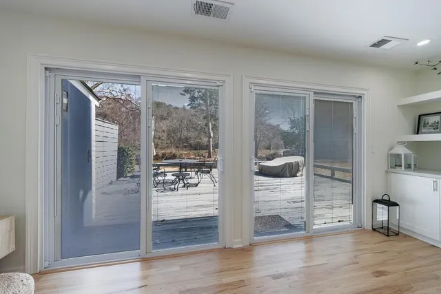 a view of a livingroom with wooden floor and furniture