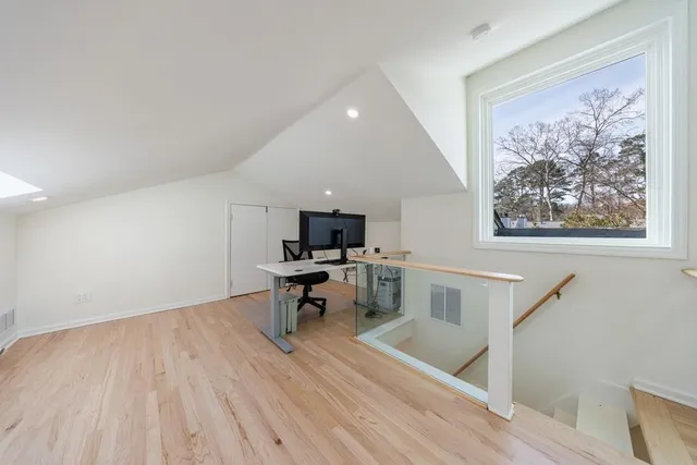 a view of a workspace with furniture and wooden floor