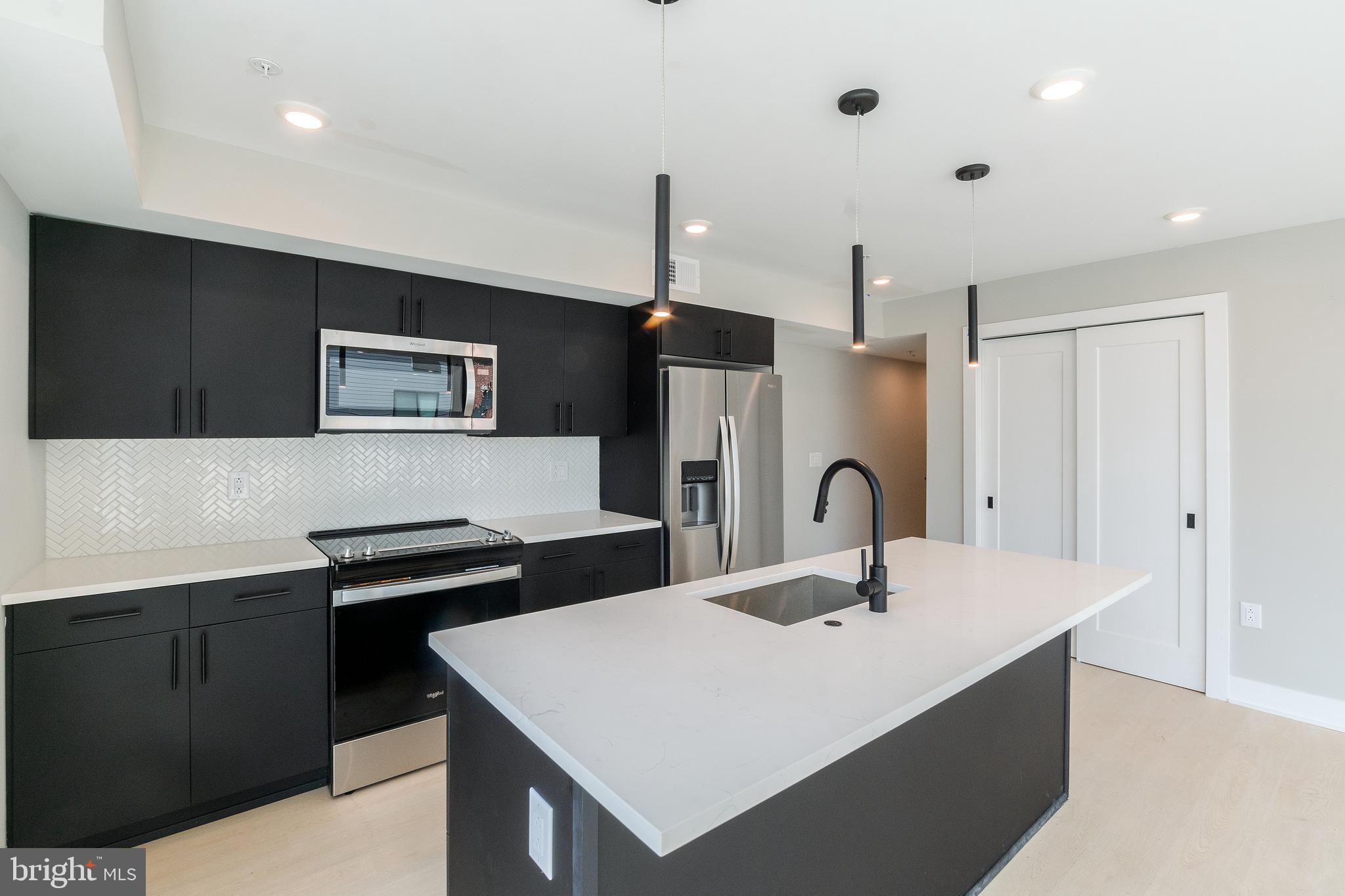 6604 Ridge Avenue, Unit 305 Philadelphia, PA 19128 - Photo 14 of 17 a kitchen with a sink and a refrigerator