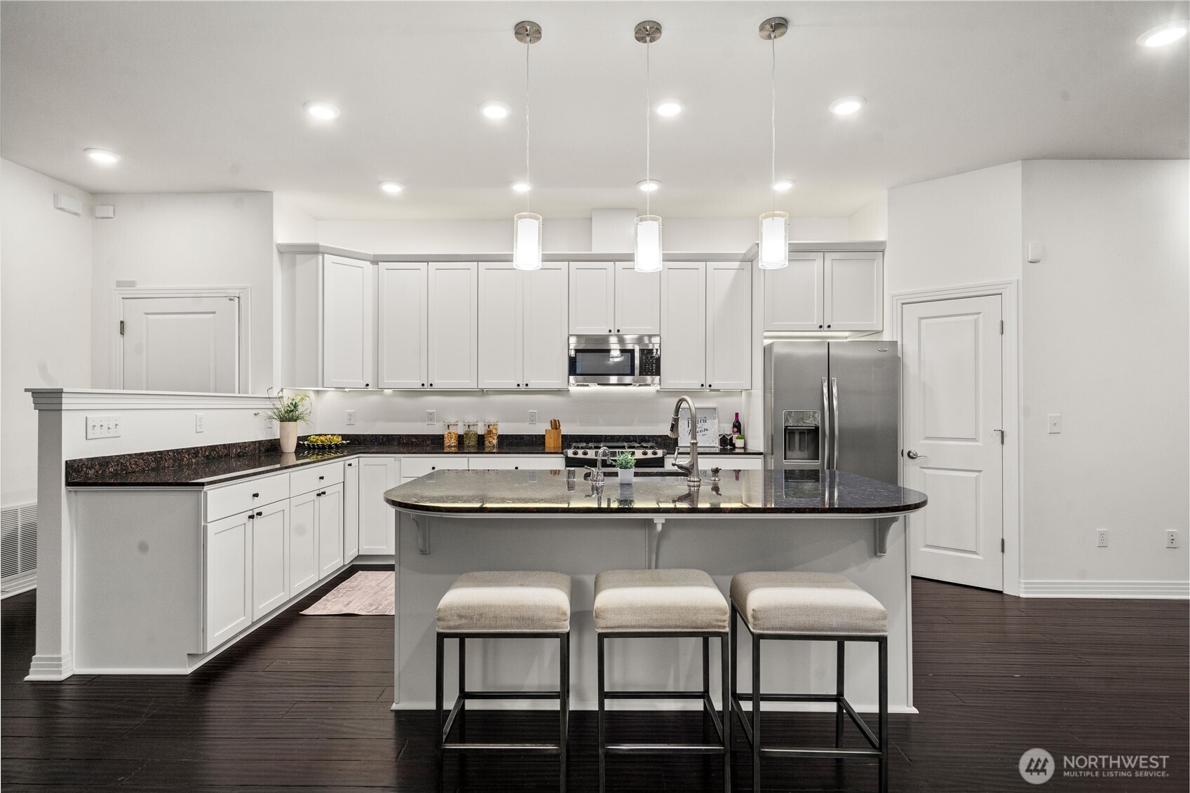 20709 Northeast 79th Street Redmond, WA 98053 - Photo 10 of 38 a kitchen with stainless steel appliances granite countertop a table chairs stove microwave and cabinets