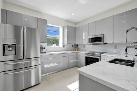 a kitchen with cabinets stainless steel appliances and window