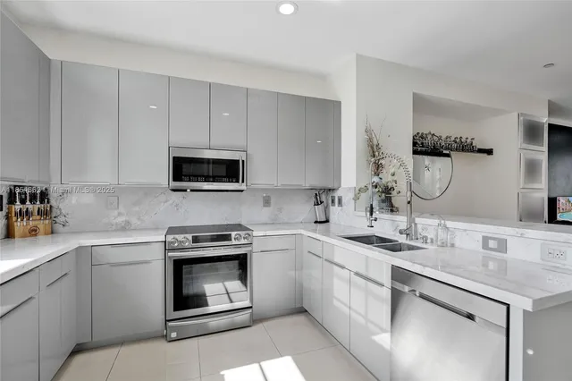 a kitchen with stainless steel appliances a sink a stove and microwave