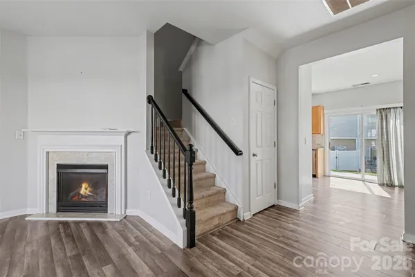 a view of a livingroom with wooden floor and a fireplace