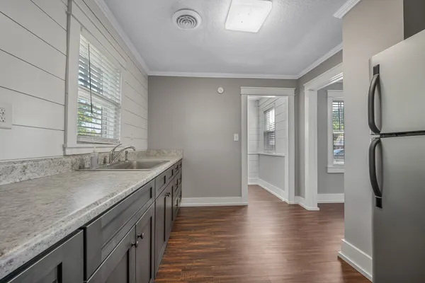 a kitchen with granite countertop a sink and a refrigerator