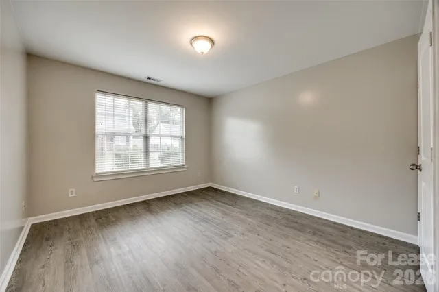 a bedroom with a large bed a flat screen tv and couches