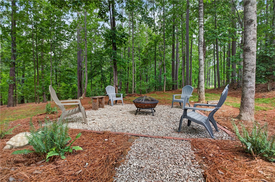 2024 Retreat Pointe Road West Union, SC 29696 - Photo 33 of 43 A tranquil fire pit area, encircled by chairs, offers a peaceful woodland retreat.