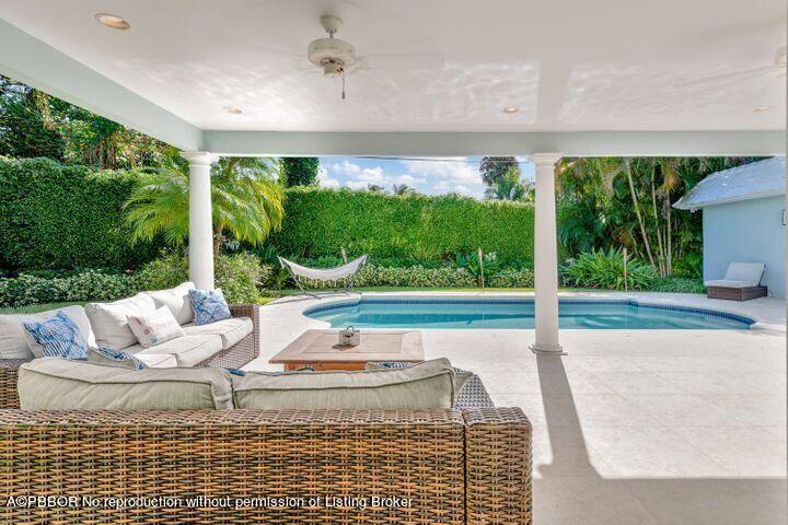 256 Mockingbird Trail Palm Beach, FL 33480 - Photo 12 of 31 a view of a patio with lawn chairs floor to ceiling window and tree