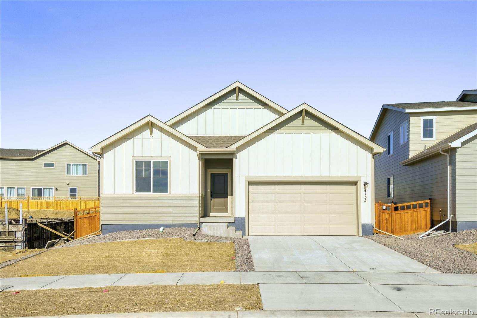 4135 Runyon Street Brighton, CO 80601 - Photo 2 of 27 a view of a white house with large windows next to a road