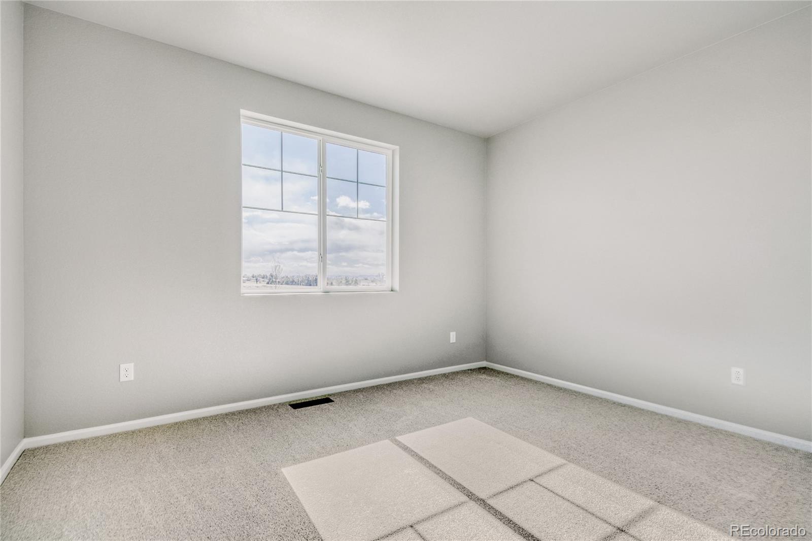 4135 Runyon Street Brighton, CO 80601 - Photo 21 of 27 an empty room with windows