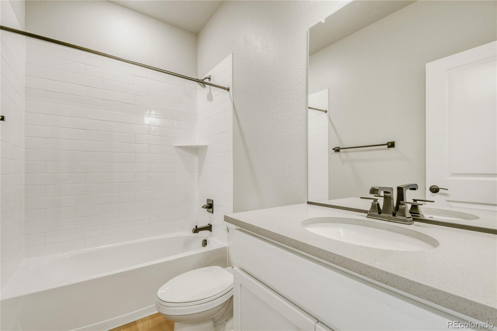 4135 Runyon Street Brighton, CO 80601 - Photo 25 of 27 a bathroom with a granite countertop sink toilet and shower